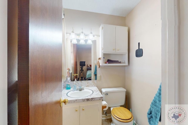 ensuite bathroom featuring connected bathroom, vanity, and toilet