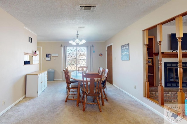 dining area featuring a notable chandelier, a glass covered fireplace, visible vents, and light colored carpet