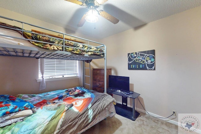 bedroom featuring a textured ceiling, baseboards, a ceiling fan, and light colored carpet