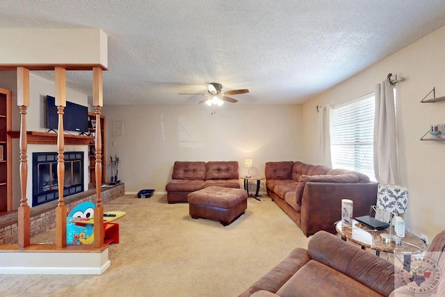 carpeted living room featuring ceiling fan, baseboards, a textured ceiling, and a glass covered fireplace