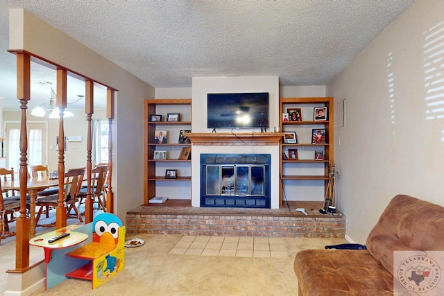 living area with a textured ceiling, carpet floors, and a glass covered fireplace