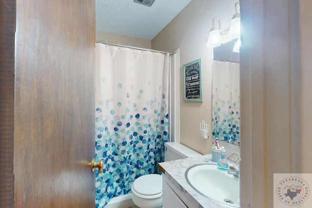 bathroom with toilet, visible vents, a textured ceiling, and vanity