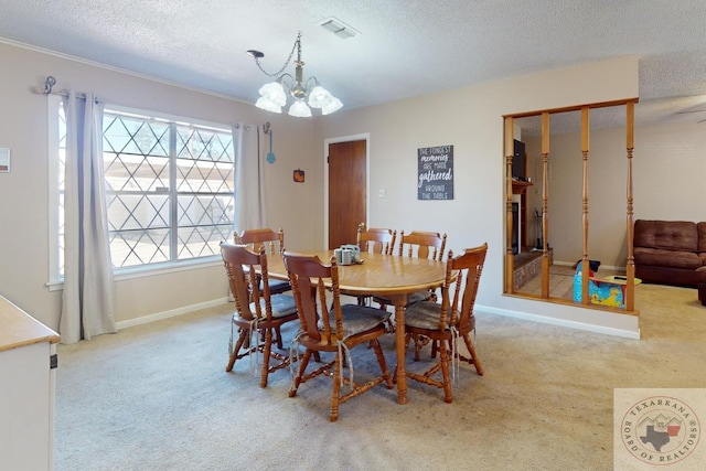 dining room with a chandelier, light colored carpet, visible vents, and a textured ceiling