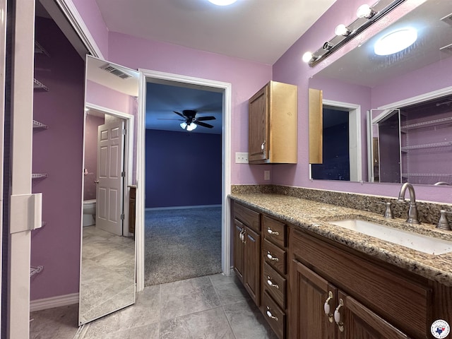 5611 Larry Dr, Texarkana, TX 75503 - bathroom with ceiling fan, vanity, visible vents, toilet, and baseboards