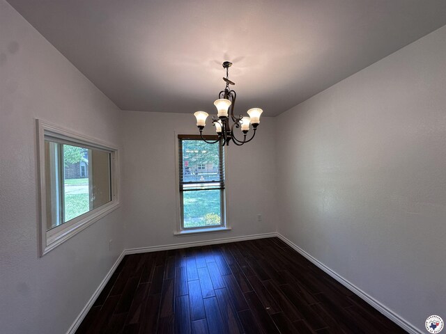 5611 Larry Dr, Texarkana, TX 75503 - spare room featuring dark wood-style flooring, an inviting chandelier, baseboards, and a wealth of natural light