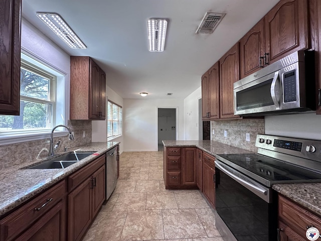 5611 Larry Dr, Texarkana, TX 75503 - kitchen featuring tasteful backsplash, visible vents, appliances with stainless steel finishes, a sink, and baseboards