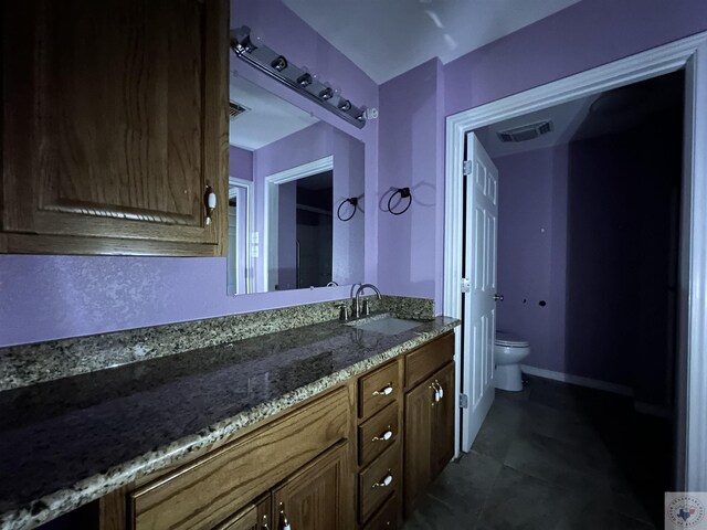 bathroom with tile patterned flooring, vanity, and toilet