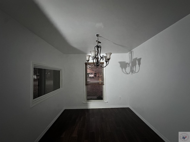 unfurnished dining area with dark hardwood / wood-style floors and an inviting chandelier