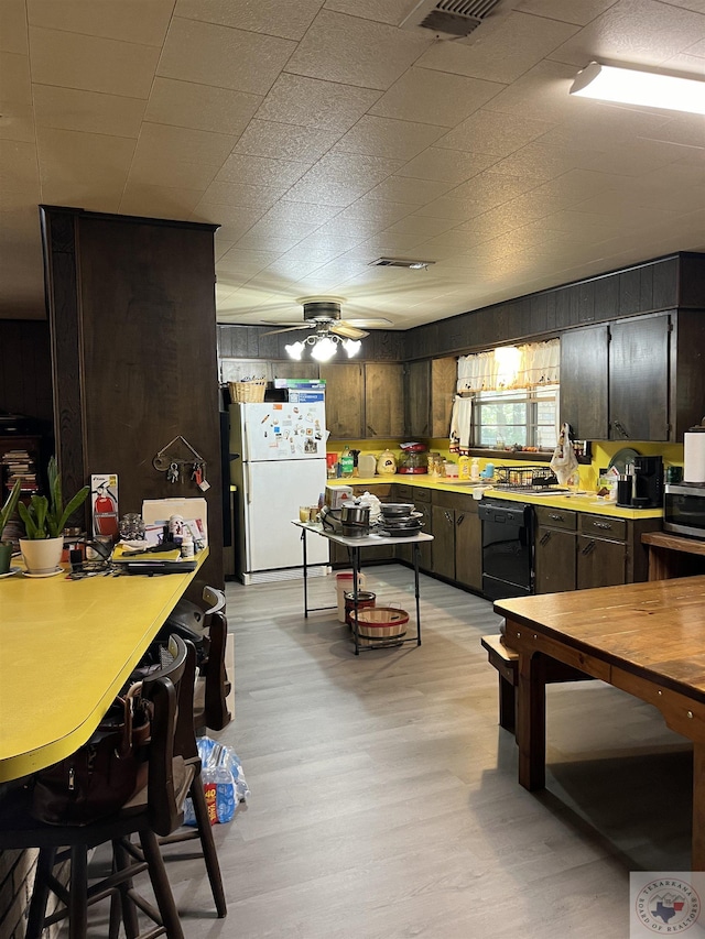 kitchen featuring light hardwood / wood-style floors, dishwasher, dark brown cabinetry, and white fridge