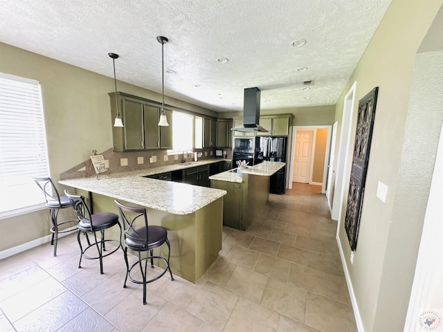 kitchen featuring a kitchen breakfast bar, kitchen peninsula, hanging light fixtures, island exhaust hood, and a kitchen island