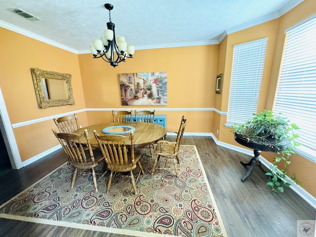 dining space with hardwood / wood-style flooring, an inviting chandelier, a textured ceiling, and crown molding