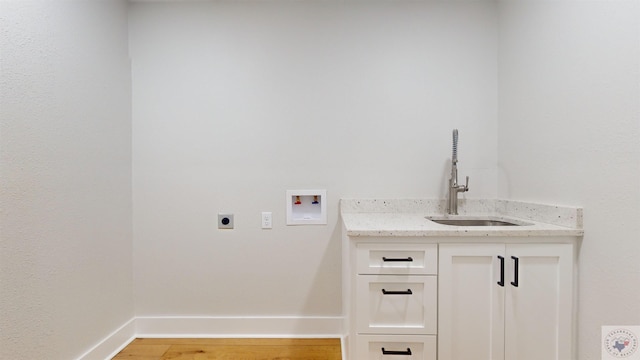 laundry room with light hardwood / wood-style floors, washer hookup, sink, electric dryer hookup, and cabinets