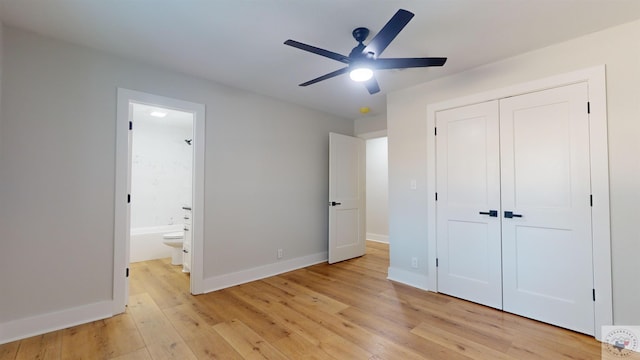 unfurnished bedroom featuring a closet, light wood-type flooring, connected bathroom, and ceiling fan