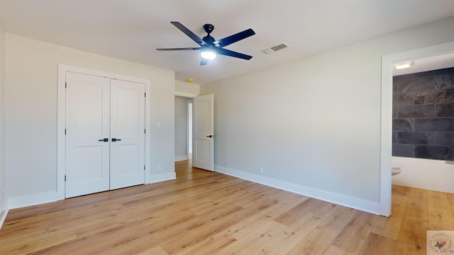 unfurnished bedroom with light hardwood / wood-style floors, ensuite bathroom, a closet, and ceiling fan