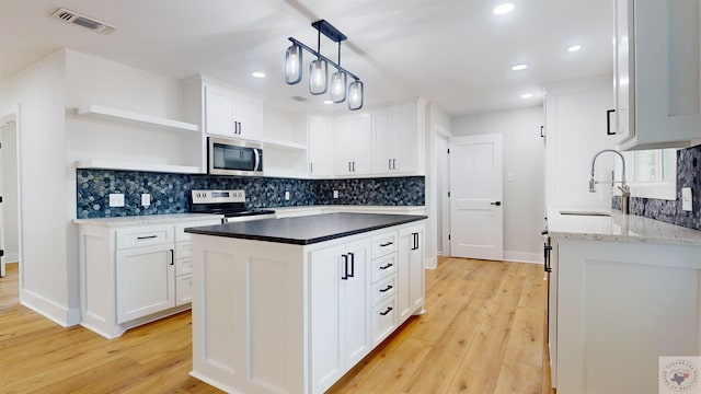 kitchen featuring white cabinets, light hardwood / wood-style floors, appliances with stainless steel finishes, and sink