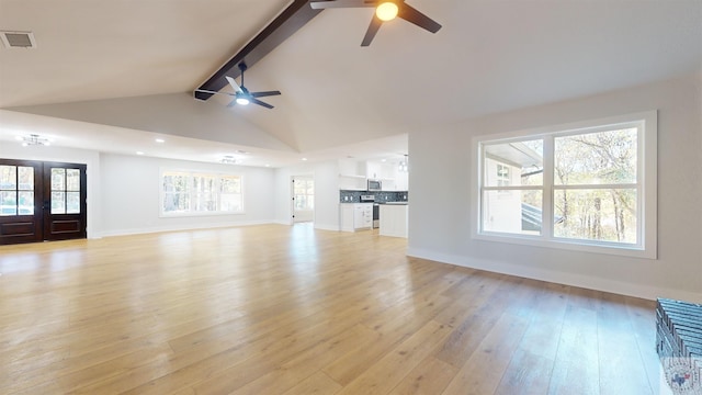 unfurnished living room featuring ceiling fan, french doors, vaulted ceiling with beams, and light hardwood / wood-style floors