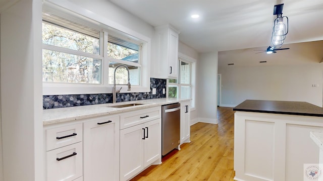 kitchen with decorative light fixtures, white cabinetry, decorative backsplash, sink, and stainless steel dishwasher