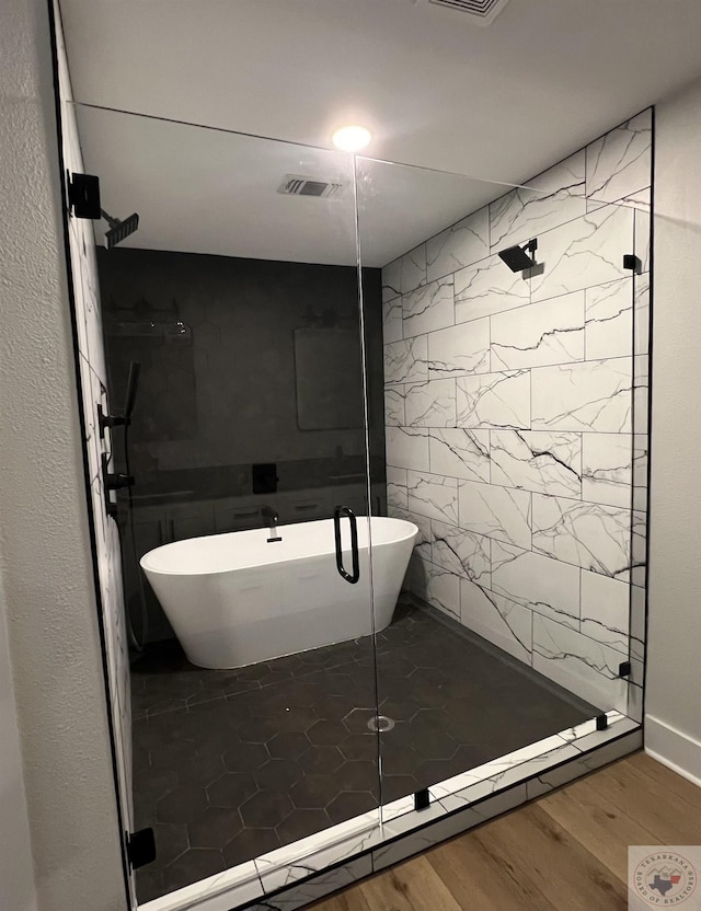 bathroom featuring hardwood / wood-style flooring and shower with separate bathtub