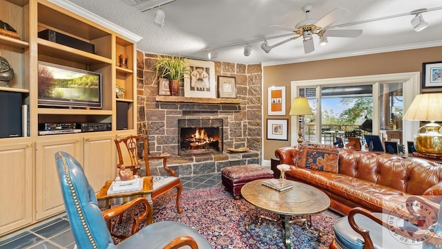 living area featuring rail lighting, a fireplace, ornamental molding, and a ceiling fan