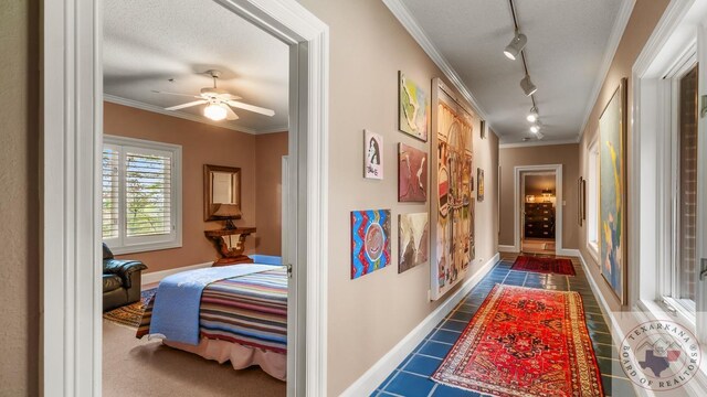 corridor with baseboards, a textured ceiling, and crown molding