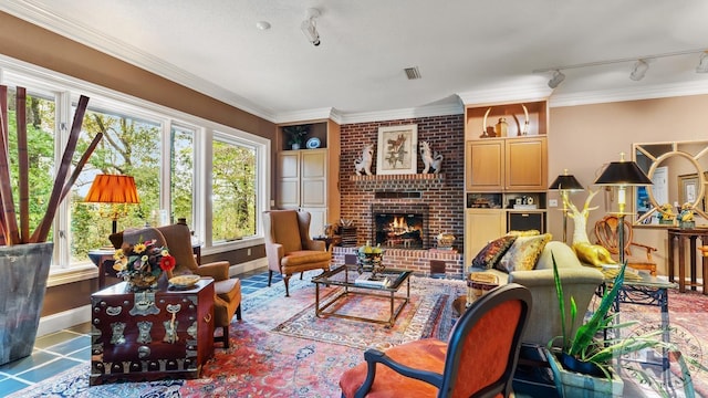 living room featuring a fireplace, visible vents, baseboards, ornamental molding, and rail lighting