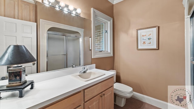 bathroom featuring toilet, a shower with door, crown molding, and vanity