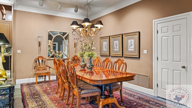 dining room with track lighting, a chandelier, and ornamental molding