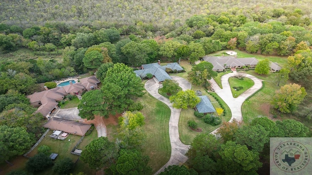 drone / aerial view featuring a wooded view