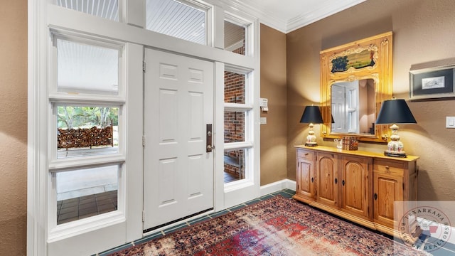 entrance foyer featuring a textured wall, crown molding, and baseboards