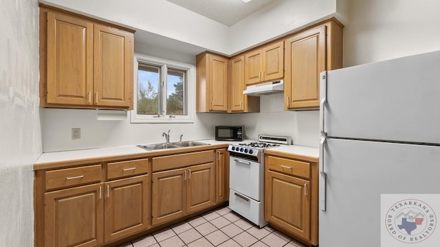 kitchen with light tile patterned floors, light countertops, a sink, white appliances, and under cabinet range hood