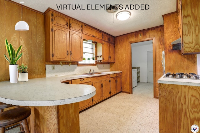129 Pine St, Maud, TX 75567 - kitchen featuring brown cabinets, a sink, light countertops, a peninsula, and light floors