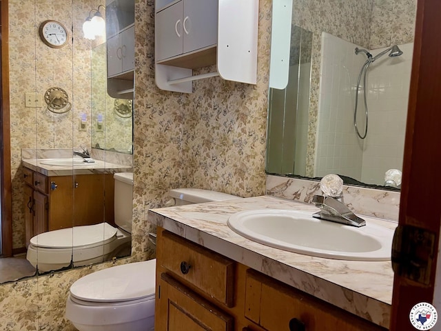 full bathroom with vanity, toilet, and a tile shower