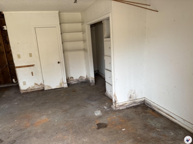 unfurnished bedroom with concrete flooring