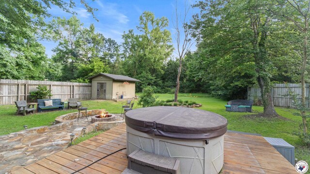 525 Longhorn Rd, Maud, TX 75567 - wooden terrace featuring a fire pit, a hot tub, a fenced backyard, and a shed