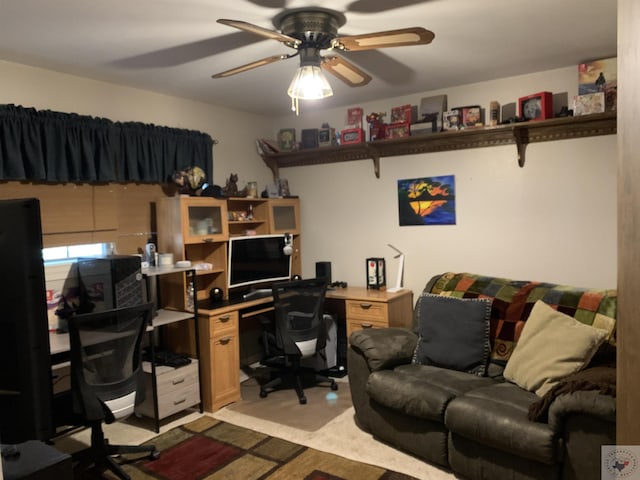 carpeted home office featuring ceiling fan