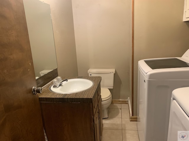 bathroom with toilet, tile patterned flooring, vanity, and washing machine and clothes dryer