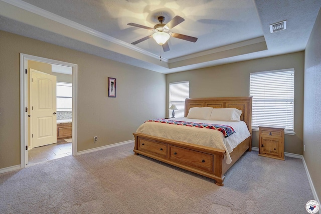 bedroom featuring crown molding, visible vents, baseboards, a tray ceiling, and carpet flooring