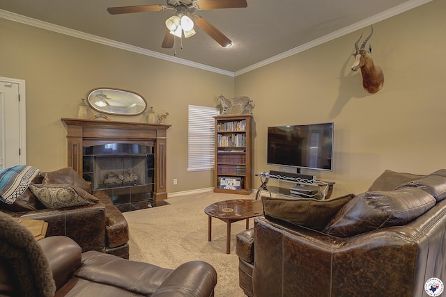 carpeted living room with crown molding, a ceiling fan, baseboards, and a tiled fireplace
