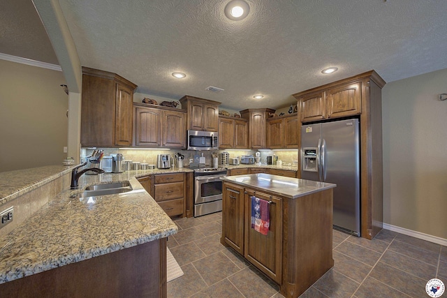 kitchen featuring visible vents, decorative backsplash, light stone countertops, a sink, and appliances with stainless steel finishes