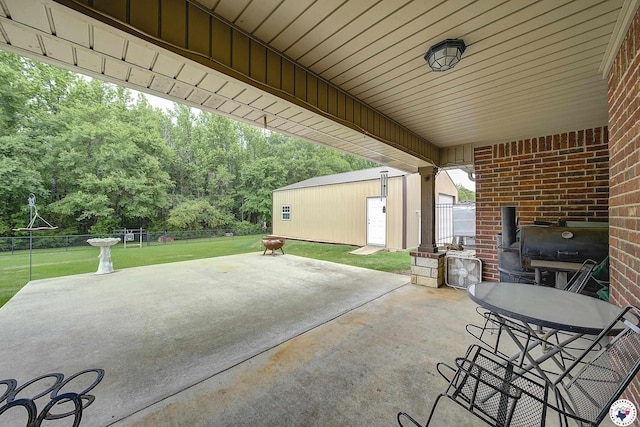 view of patio featuring an outdoor structure, fence, and a grill