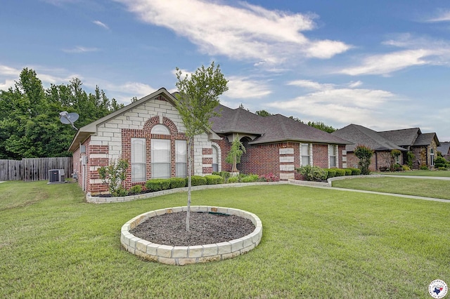 view of front of house with central AC unit, a front yard, and brick siding