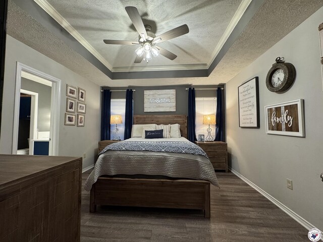 bedroom with a tray ceiling, a textured ceiling, baseboards, and ornamental molding