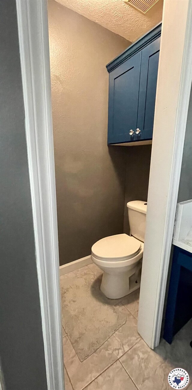 bathroom featuring marble finish floor and toilet