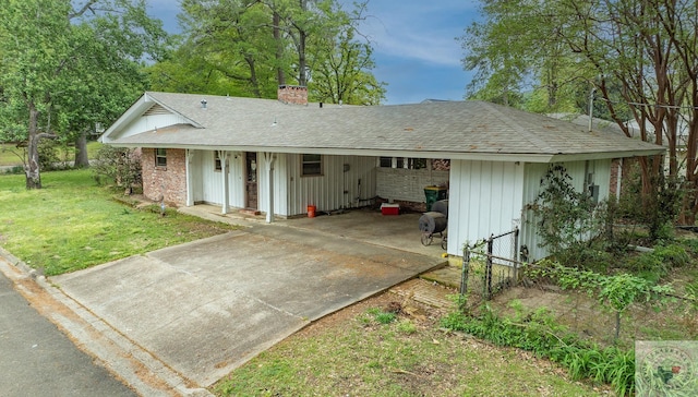 rear view of house featuring a carport and a lawn