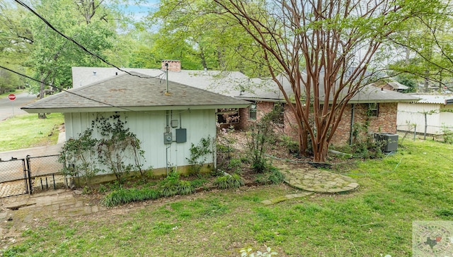 back of property with central air condition unit and a lawn