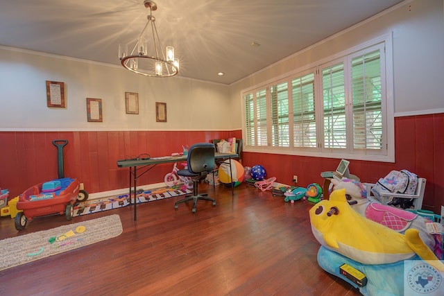 playroom featuring ornamental molding, hardwood / wood-style flooring, and an inviting chandelier