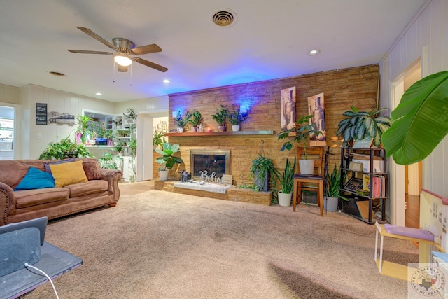 carpeted living room featuring ceiling fan and a fireplace