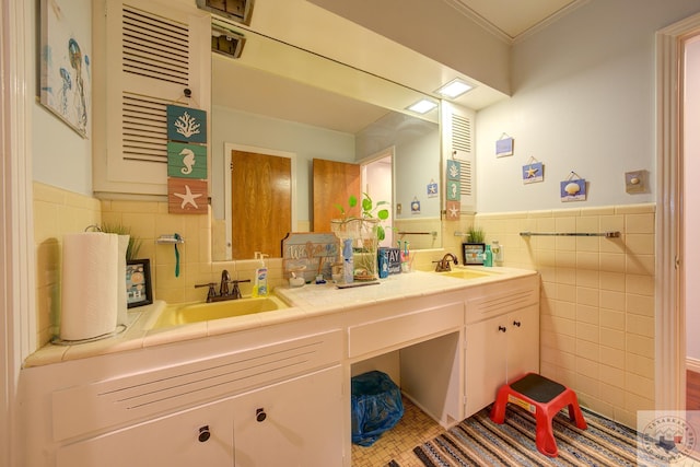 bathroom with tile walls, vanity, and ornamental molding