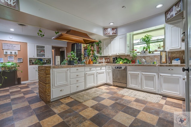 kitchen with stainless steel dishwasher, white cabinets, sink, kitchen peninsula, and backsplash