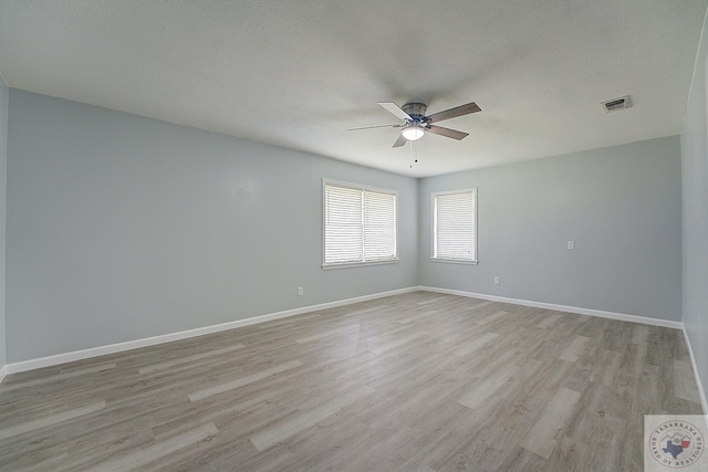 unfurnished room with ceiling fan, light hardwood / wood-style flooring, and a textured ceiling